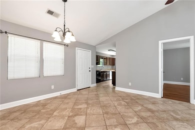 Spare room with a chandelier, high vaulted ceiling, baseboards, light tile patterned floors, and a ceiling fan