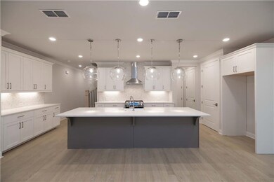 The welcoming kitchen has a huge island for entertaining. *Please note the photos shown are representative of the plan but are not of the actual home.