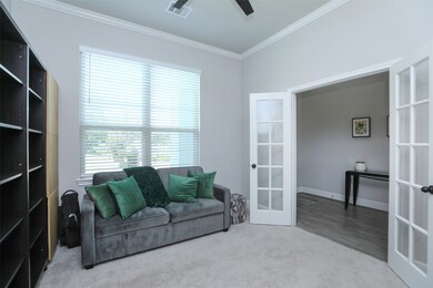 Pass through the threshold to your right, where elegant French doors unveil a versatile 12 x 11 private home office/study. Enhanced with a lit ceiling fan, faux wood window coverings, neutral carpet and paint, and exquisite crown molding, this area seamlessly merges functionality with sophistication. This adaptable space could also serve as an additional bedroom, playroom, or cater to any other desire, accommodating all your lifestyle needs.