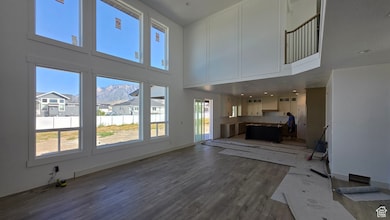 Unfurnished living room featuring a mountain view, dark wood-style flooring, and a high ceiling