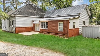 View of front of property with brick siding, a front yard, and crawl space