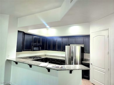 Kitchen featuring black appliances, a kitchen bar,