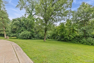 View of side of property featuring a garage, concrete driveway, a chimney, stucco siding, and a yard