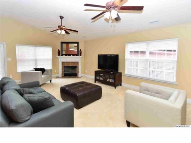 DOUBLE CEILING FANS HANG FROM THE CEILING AND A CORNER FIREPLACE PROVIDES CHARACTER AND WARMTH TO THE ROOM.