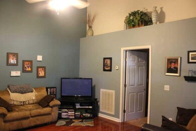 Spacious living room with rich dark flooring and p