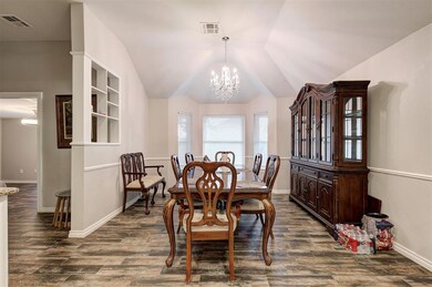 Dining space featuring a chandelier, dark wood finished floors, and lofted ceiling