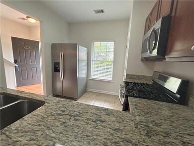Kitchen with stainless steel appliances, light tile patterned floors, and stone counters