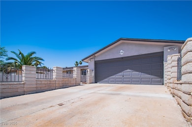 Garage featuring concrete driveway and a gate