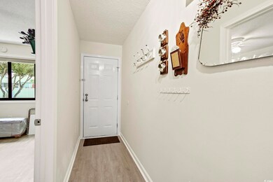 Corridor featuring a textured ceiling and wood-typ