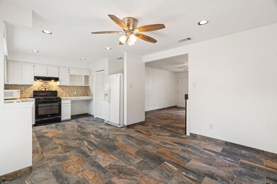 Kitchen featuring white appliances, ceiling fan, 
