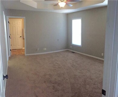 Master bedroom offers tray ceiling with fan, big w