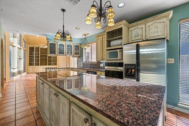 Kitchen with pendant lighting, an inviting chandelier, a healthy amount of sunlight, and appliances with stainless steel finishes