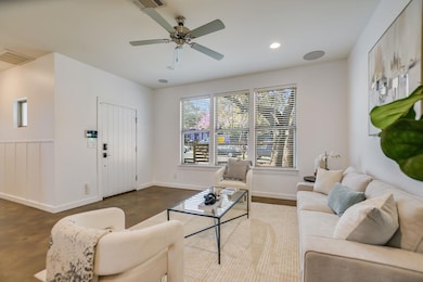 Living area with visible vents, a ceiling fan, fi