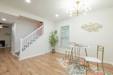Dining area with stairway, hardwood / wood-style floors, a chandelier, recessed lighting, and a brick fireplace