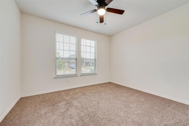 Carpeted spare room with ceiling fan