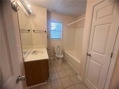 Full bath with vanity, tile patterned flooring, a textured ceiling, and shower / washtub combination