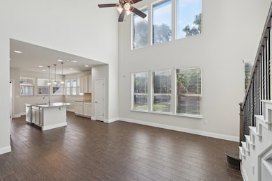 Unfurnished living room featuring a ceiling fan, 