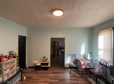 Living area with dark wood-style flooring and a textured ceiling