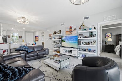 Living room featuring arched walkways, recessed lighting, light tile patterned floors, and a chandelier