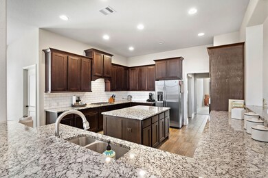 Large kitchen with granite countertops and subway backsplash.