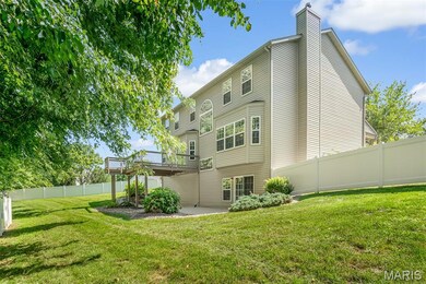 Rear view of house featuring a deck, a Viinyl fencing, and a patio area