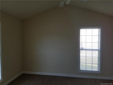 Master bedroom has vaulted ceiling and fan.