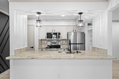 Kitchen featuring hanging light fixtures, applianc