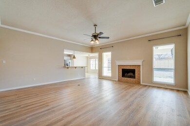 spacious living room with a wealth of natural light, hardwood / wood-style floors, ceiling fan, and a tiled fireplace