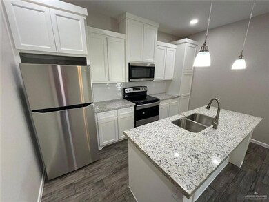 Kitchen featuring appliances with stainless steel finishes, dark wood-style floors, white cabinetry, decorative backsplash, and recessed lighting