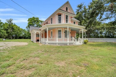 Back of property featuring covered porch and a law