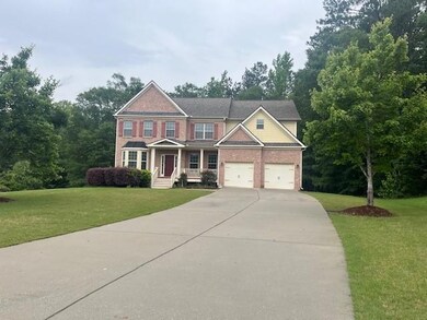 View of front of property with concrete driveway, a front yard, covered porch, and brick siding