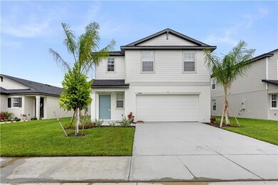 Traditional home featuring concrete driveway, a garage, a front yard, and stucco siding