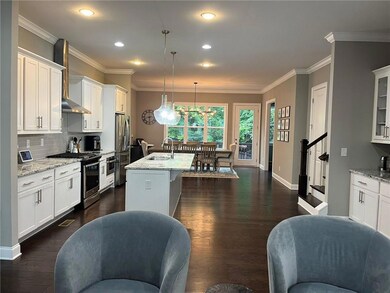 Kitchen featuring stainless steel appliances, a sink, wall chimney exhaust hood, white cabinetry, and crown molding