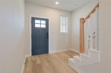 Foyer with stairway, light wood finished floors, b