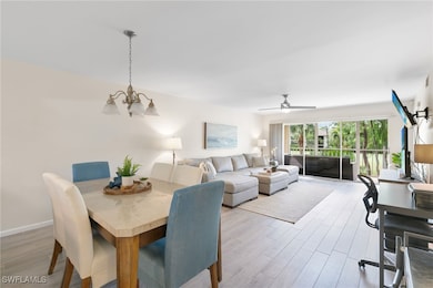 Dining area featuring light wood-style tile flooring, ceiling fan, and a chandelier