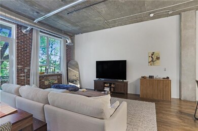 Living room with dark wood-style floors and brick wall