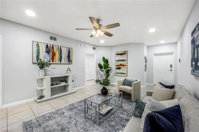 Tiled living area featuring ceiling fan, baseboard