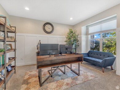 Office featuring light colored carpet, a decorative wall, recessed lighting, and wainscoting