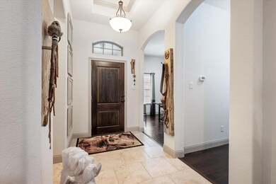 Foyer with a tray ceiling and light hardwood / woo