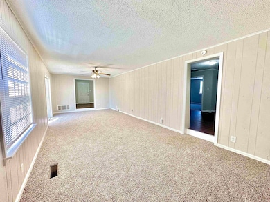 Carpeted empty room with visible vents, a ceiling 