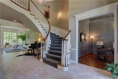 Entry boasts grand staircase and tile flooring.  E