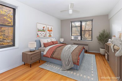 Bedroom featuring radiator, light wood finished floors, a ceiling fan, and cooling unit