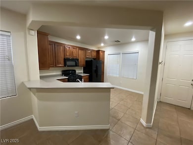 Kitchen featuring brown cabinetry, black appliance