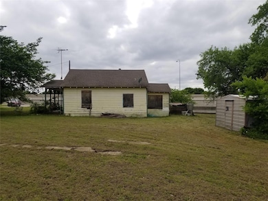 View of property exterior with a shed and a lawn
