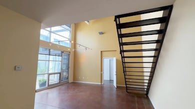 Unfurnished living room with plenty of natural light, a towering ceiling, and finished concrete floors
