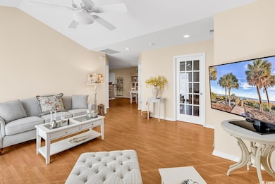 Living room with vaulted ceiling, baseboards, ligh
