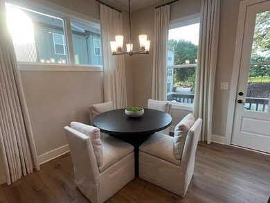 Dining area with a chandelier and dark wood-style flooring