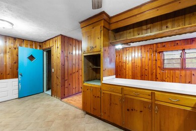 Kitchen featuring brown cabinets, wooden walls, li