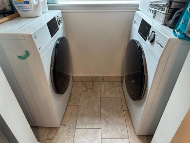 Washroom featuring baseboards and washing machine