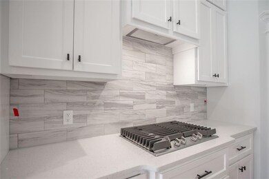 Kitchen with decorative backsplash, white cabinetr